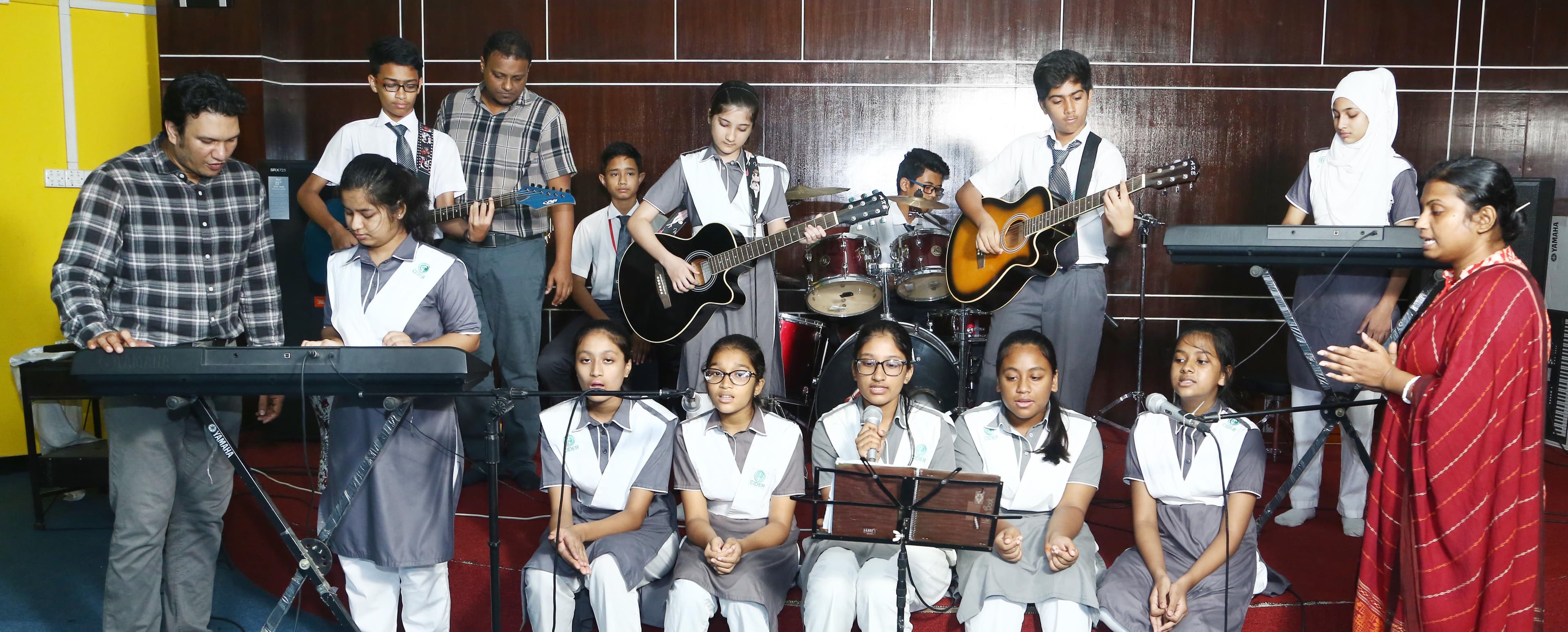 Students actively participating in a music class, playing various instruments